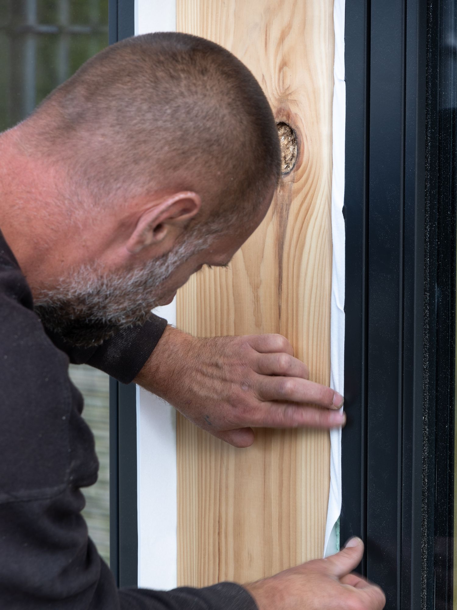 Tømrer monterer vindusomramming